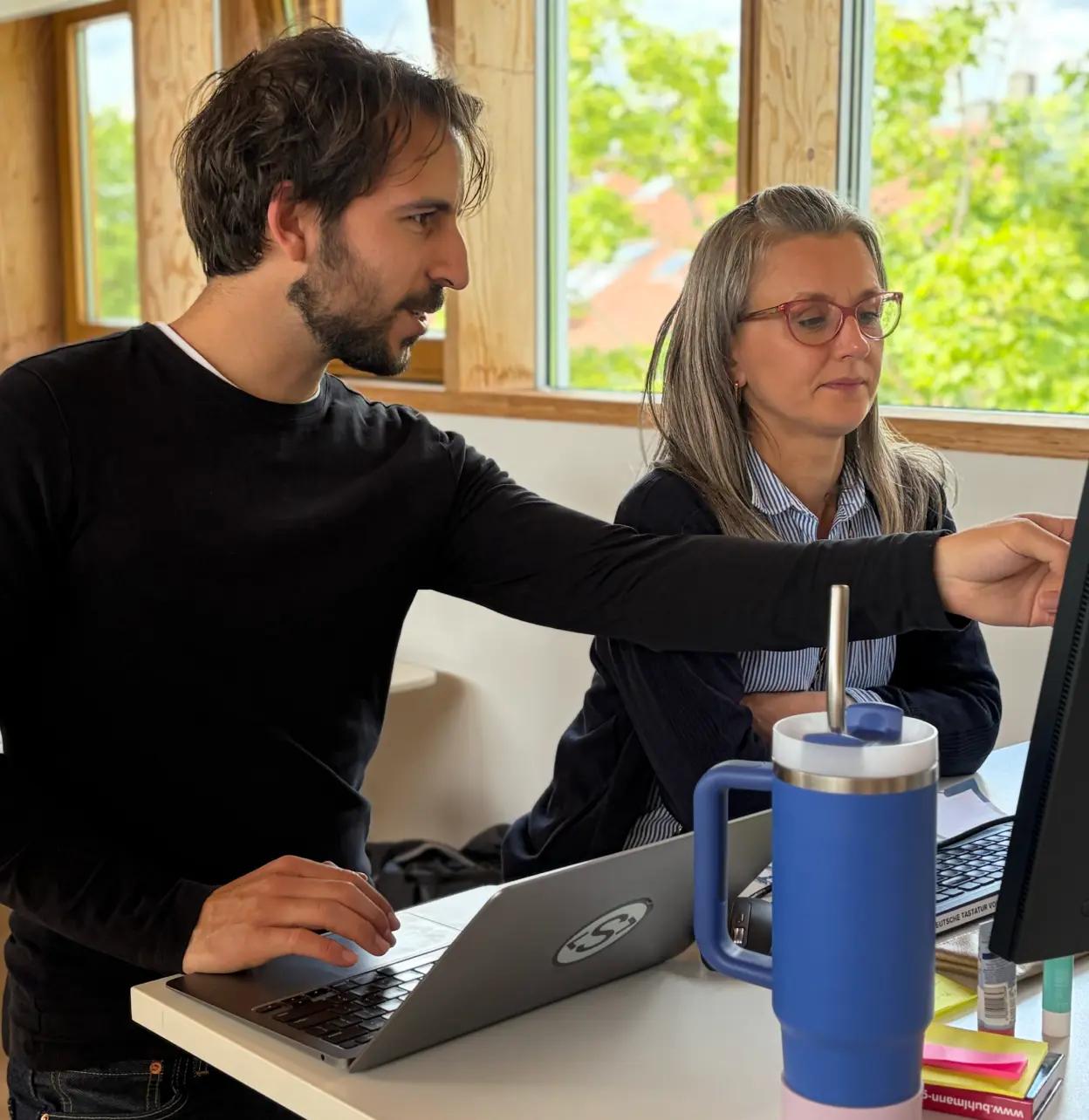Two people working together at a screen